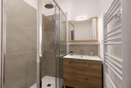 ein Bad mit einer Dusche und einem Waschbecken in der Unterkunft Balda'Quand Médiéval in Carcassonne