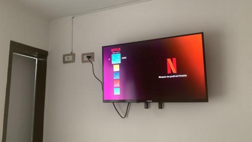 TV de pantalla plana colgada en la pared en Hotel Portobello La Ceja, en La Ceja