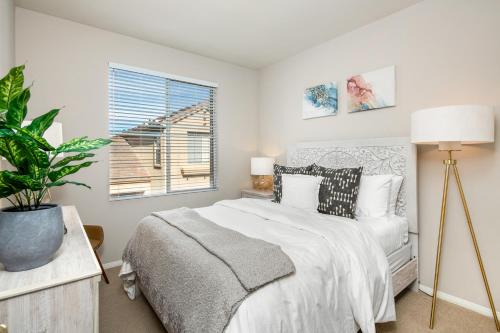 een witte slaapkamer met een bed en een raam bij Cozy 3BR Newport Coast Villa in Gated Community in Newport Beach