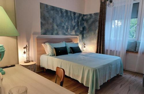 a bedroom with a bed with a blue wall at L'angolo di Luna in Gorizia