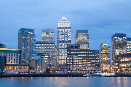 a view of a city at night with at Entire Apartment next to Canary Wharf in London in London