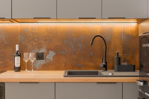a kitchen with a sink and a bottle of wine at Prestige Apartments 19 in Wrocław