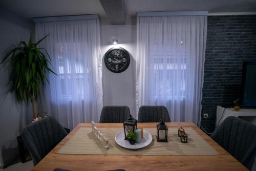 a dining room table with a clock on the wall at Villa KIKO Mountain Village in Bitola