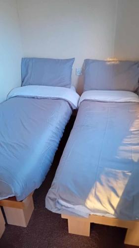 two beds sitting next to each other in a room at Loch Heron View in Newton Stewart