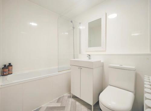 ein weißes Bad mit einem WC und einem Waschbecken in der Unterkunft Dalesman Apartment - 10 Minutes Walk to Manchester City Centre, Oxford Road, Chinatown, Universities in Manchester