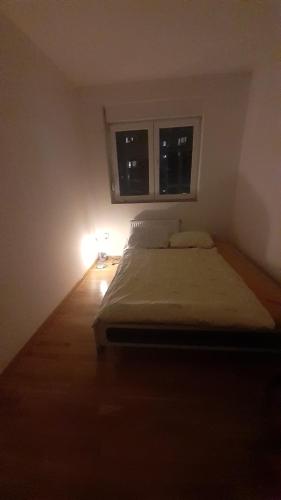 een kleine slaapkamer met een bed en een raam bij DUNAV 1 in Smederevo