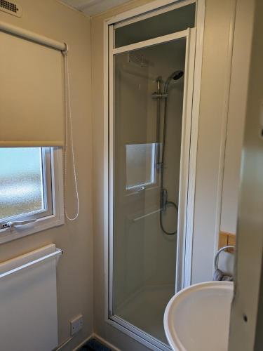 a bathroom with a shower and a sink at Loch Heron View in Newton Stewart