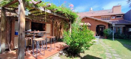 une pergola avec une table et des chaises dans une arrière-cour dans l'établissement Tanino Home Suites, à Mendoza