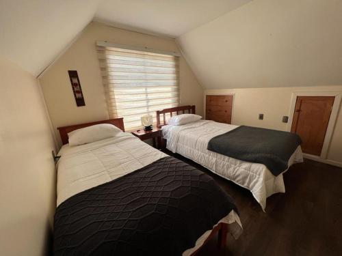 a bedroom with two beds and a window at Casa full in Castro