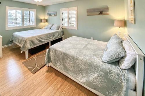 a bedroom with two beds and two windows at Outrigger 114 in Ocean City