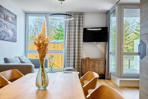 a living room with a table with a vase of flowers at Levandule, Růže by Mountain ways in Abertamy