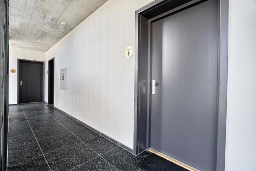a hallway with two doors and a tile floor at Levandule, Růže by Mountain ways in Abertamy