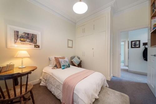 a bedroom with a bed and a desk with a lamp at Sandringham Royale in Sandringham