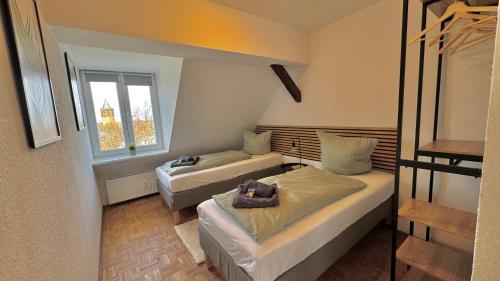 een kleine kamer met 2 bedden en een raam bij ApartmentOase #2 in Merseburg