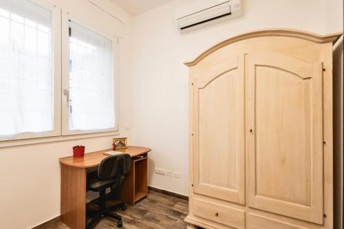 a room with a desk and a wooden door at Divine DANTE's Apartment in Ravenna