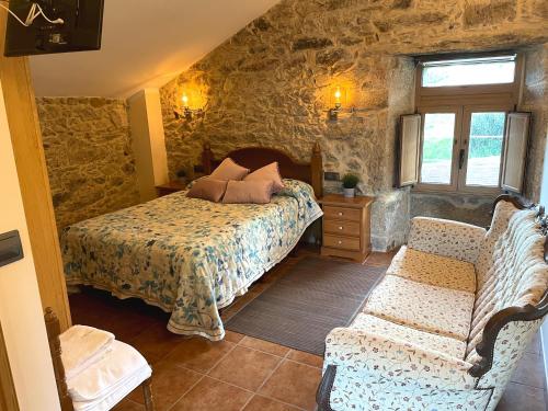 ein Schlafzimmer mit einem Bett und einem Sofa in der Unterkunft Vivienda Vacacional Vila Castriño en las Rias Baixas in Tarragona