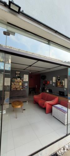 uma sala de estar com um sofá vermelho e uma mesa em Kaleidoscopio Hostel em São Paulo