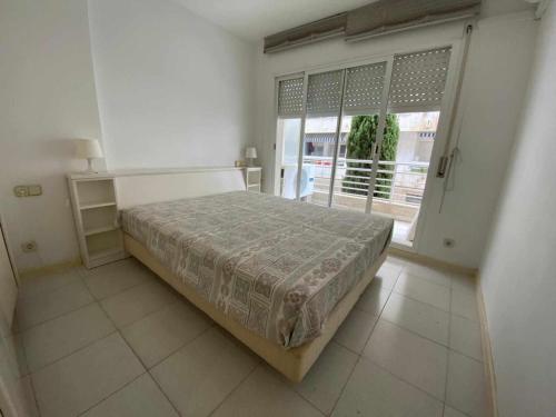 a bedroom with a bed and a large window at Nautic wifi Parking y a 150 metros de la playa in Tossa de Mar