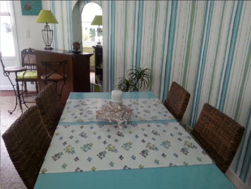 une table à manger avec un chiffon bleu et des chaises dans l'établissement Arcachon Pereire T2 75m2 en rdc + jardin privé, à Arcachon