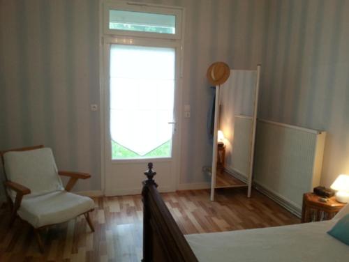 une chambre avec un lit, une chaise et une fenêtre dans l'établissement Arcachon Pereire T2 75m2 en rdc + jardin privé, à Arcachon