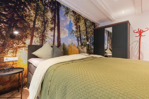 a bedroom with a bed in a forest mural at Apart Feine Zeit - Apartment Waldele in Schönwies