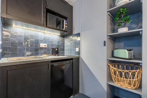 a small kitchen with a sink and a dishwasher at Opéra, Grand Boulevard 9ème, suite avec jacuzzi in Paris