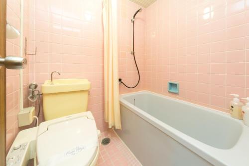 a pink bathroom with a toilet and a bath tub at 8－1 - Vacation STAY 29648v in Kochi