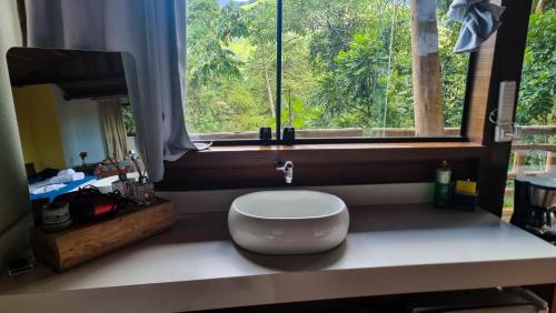a white bowl sitting on a counter next to a window at Villa Gatto Chalés - Visconde de Maua in Bocaina de Minas