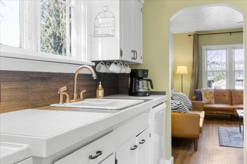 a kitchen with a sink and a living room at C Street Charm in Coeur d'Alene