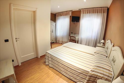 una camera da letto con un grande letto con una coperta a righe di LOCANDA LE 4 CIACOLE a Roverchiara