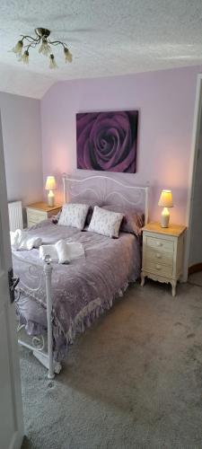 1 dormitorio con 1 cama y 2 mesitas de noche con lámparas en Wisteria Cottage an authentic and enchanting cottage experience, en Aberdare