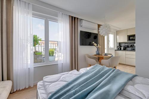 a bedroom with a bed and a table with chairs at Petit Repit by Grand Apartments in Sopot