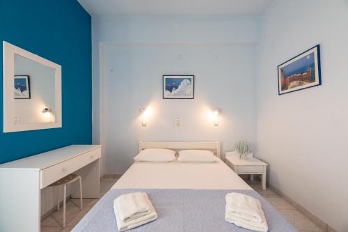 a bedroom with a bed and a blue wall at Galini me thea in Chrissi Akti