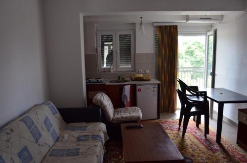 a living room with a couch and a table and a kitchen at Apartmani Tomar in Star Dojran