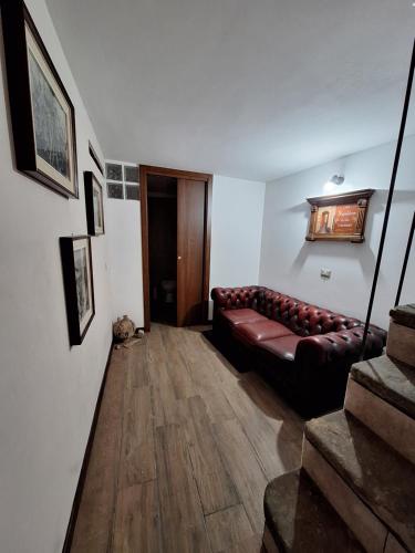 uma sala de estar com um sofá de couro castanho num quarto em Casa Napoleone em Sora