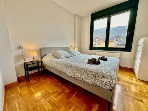 sypialnia z łóżkiem i dużym oknem w obiekcie Encantador Piso a 150m del Tren w mieście Pola de Lena