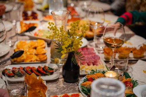 a table topped with plates of food and a vase of flowers at Casa Galya with private patio by GardaDoma in Brenzone sul Garda