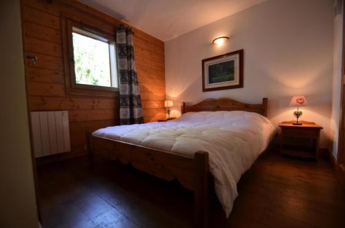a bedroom with a large bed in a room with a window at Résidence Hameau Des Marmottes - 4 Pièces pour 6 Personnes 514 in Les Menuires