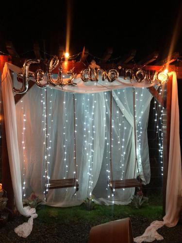 a table with white curtains and lights on it at Recanto dos Pássaros in Alto Caparao