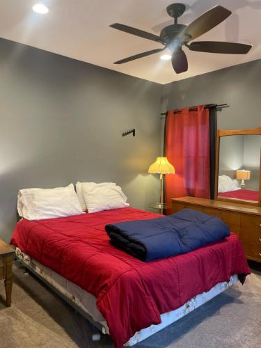 a bedroom with a bed with a ceiling fan at Dartt's Park Flat in Owatonna