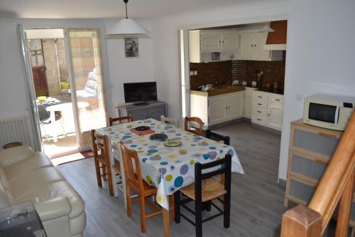 uma cozinha e sala de jantar com mesa e cadeiras em Gîte familial chaleureux à la campagne 20mn FUTUROSCOPE em Savigny-Lévescault