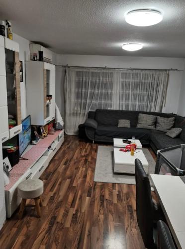 sala de estar con sofá negro y suelo de madera en Dream Word en Backnang