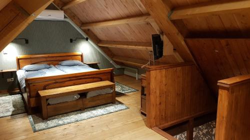 a bedroom with a bed and a tv in a attic at Bed Op Steeg Vakantiehuis / Bed and Breakfast in De Steeg