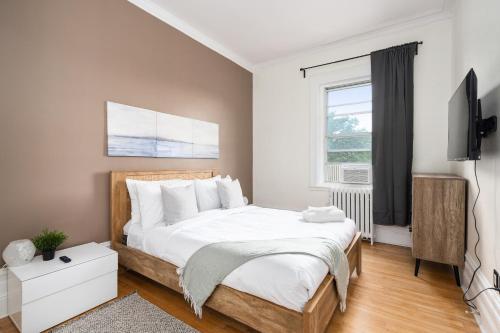 een slaapkamer met een groot bed en een televisie bij Penthouse / Sunset Private Terrace, 6Bdrs-13Guests in Montreal