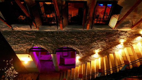 an overhead view of a staircase at night with purple lights at 1800's in Gjirokastër