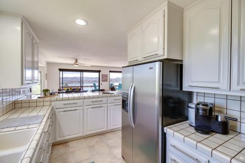 a kitchen with white cabinets and a stainless steel refrigerator at Idyllic Kelseyville Home with 2 Decks and Views! in Kelseyville