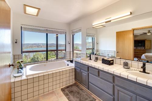 a bathroom with two sinks and a tub with a large window at Idyllic Kelseyville Home with 2 Decks and Views! in Kelseyville