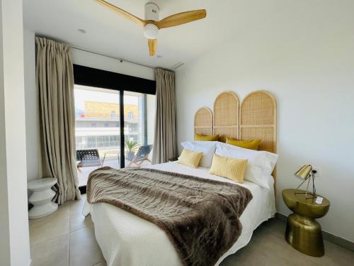 a bedroom with a large bed and a balcony at La casa de Lola in Motril