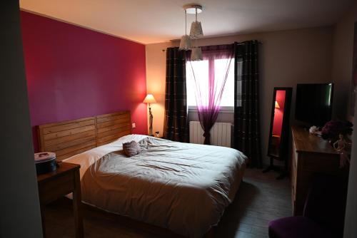 une chambre avec un grand lit et une fenêtre dans l'établissement A L'Orée du Bois, à Baron