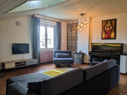 sala de estar con sofá y piano en Lago Maggiore - Loft Apartment, en Ispra